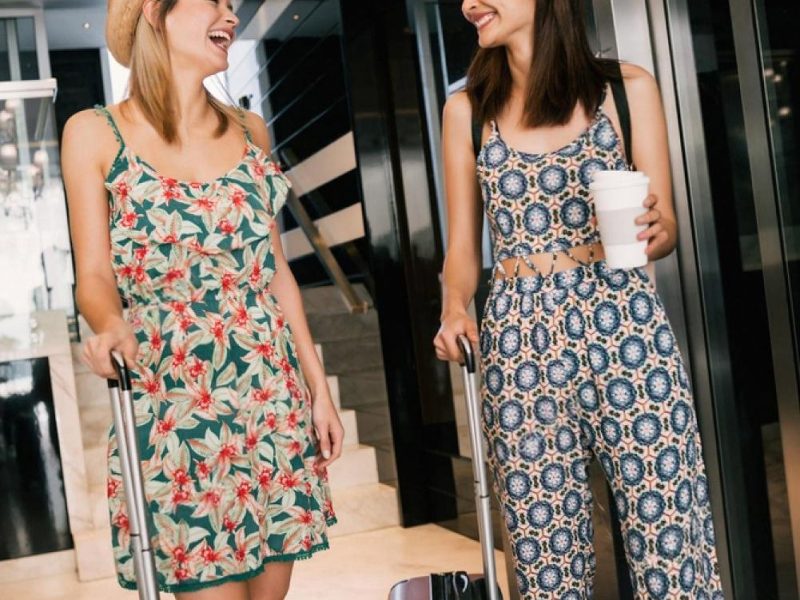 Two women with suitcases arriving at a Dubai hotel lobby after online check-in